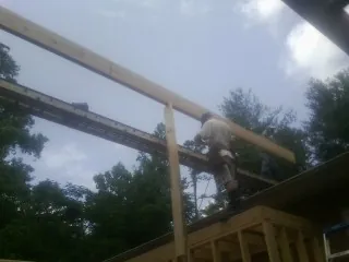 Carpenter setting a ridge beam over a new addition frame — Ice Dam Removal by Roofing Brothers in Souderton