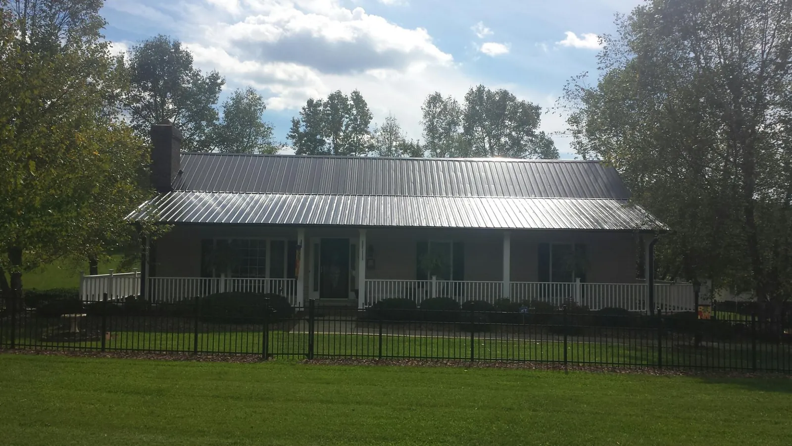 Gray metal roof on a brick ranch with a full width front porch — Gutter Guard Installation work by our crew in Souderton