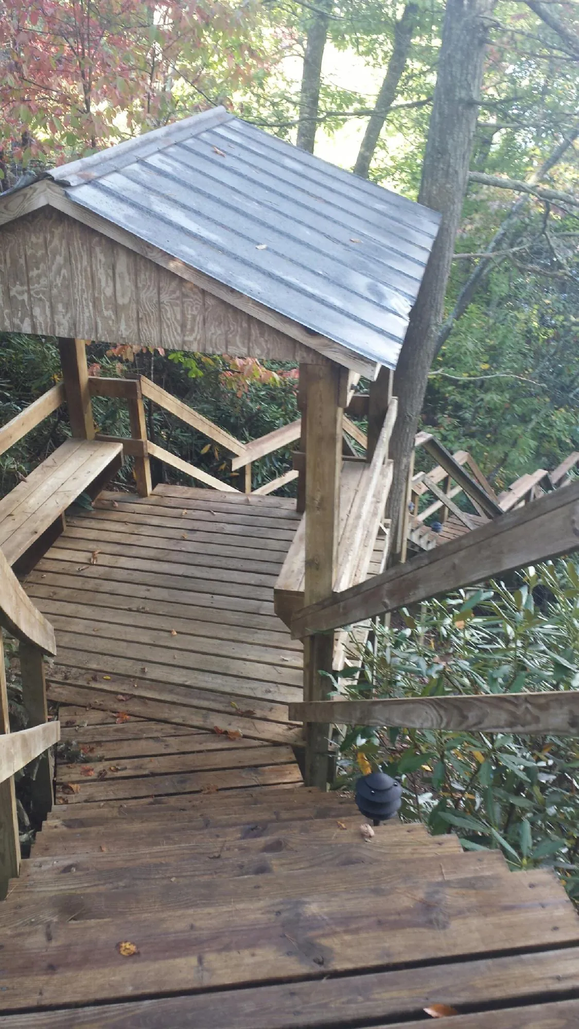 Metal roofed shelter over wooden steps on a wooded walkway — Skylight Repair & Installation work by our crew in Souderton