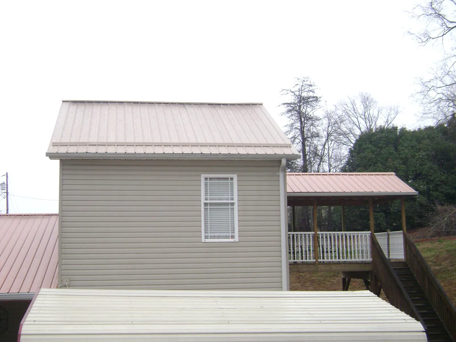 Tan metal roofs on a two story addition and attached porch, from a Roof Replacement job in Souderton
